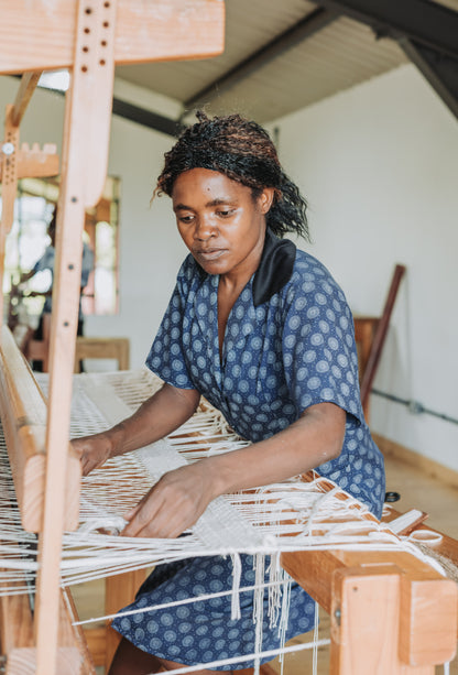 Woman weaving on a loom in a workshop setting
